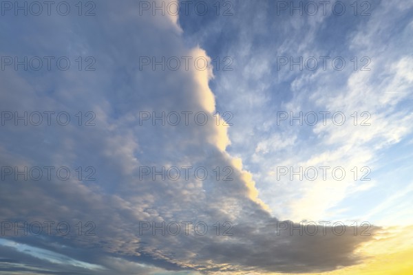 Cloud front with grey stratocumulus below right left and bright altocumulus clouds above