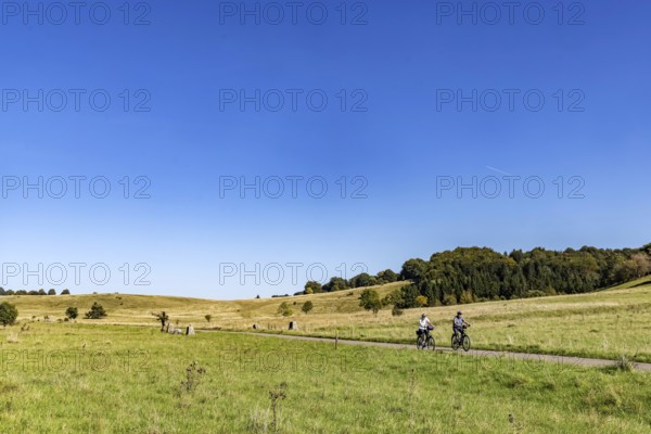 Pristine landscape in the Swabian Alb biosphere reserve with blue skies and cyclists. The former