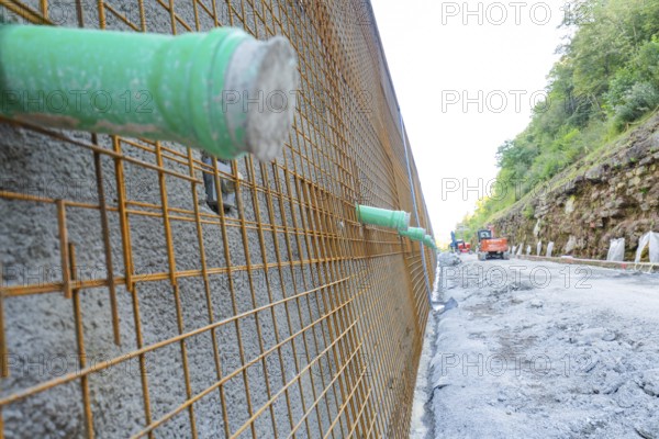 Close-up of a construction wall with metal mesh and green pipes, Hermann Hessebahn construction