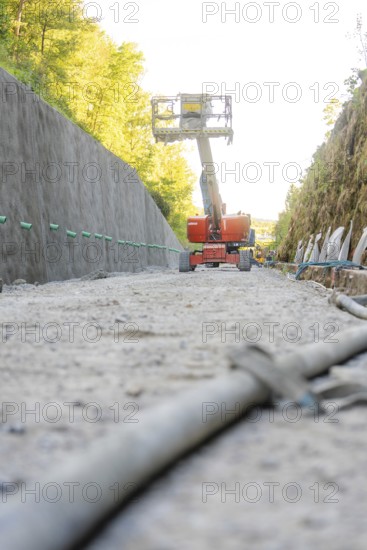 On a construction site, a working platform lifts between concrete walls in the forest, Hermann