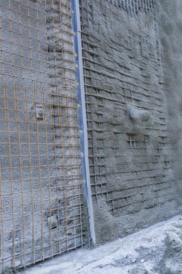 Close-up of a concrete wall with visible wire mesh on a construction site, Hermann Hessebahn