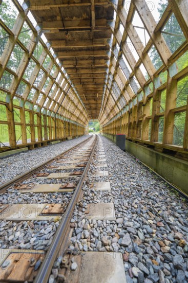 Open wooden tunnel with a view of daylight through wooden structures, construction of the Hermann