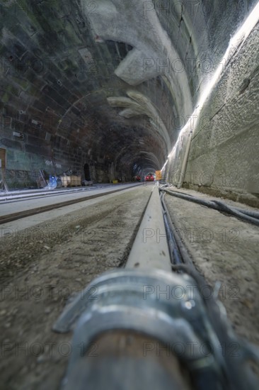 Rough tunnel construction with railway tracks from a low perspective, construction of the Hermann