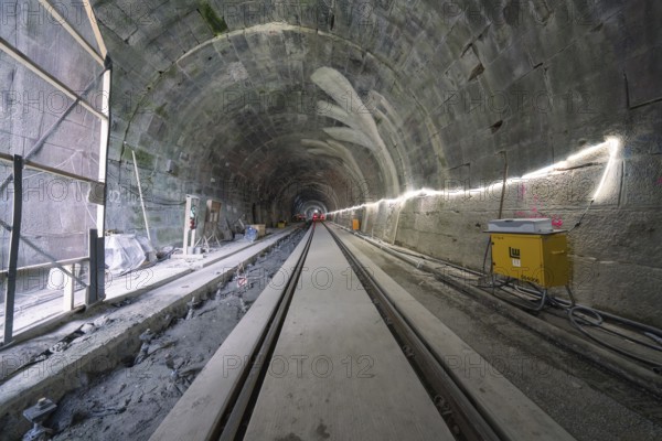 A tunnel still under construction with rails and artificial lighting, construction of the Hermann