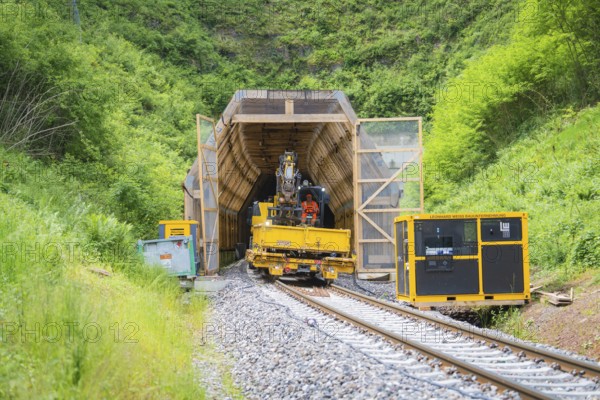 Construction vehicle near a tunnel in a green, natural environment, construction of the Hermann