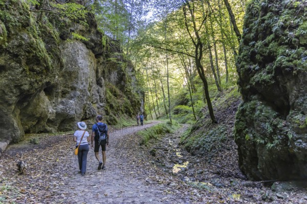 Trailfinger Gorge near Seeburg in the Swabian Alb. Man and woman with dog on a hike through the
