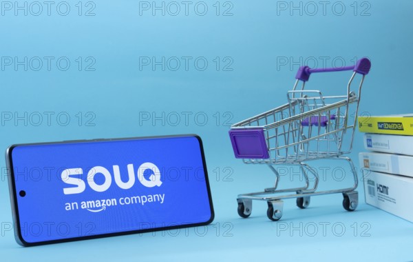 Dhaka, Bangladesh- 03 July 2025: Smartphone with Souq logo next to a small shopping cart and boxes