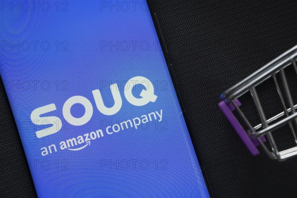 Dhaka, Bangladesh- 03 July 2025: A smartphone displaying the Souq logo next to a miniature shopping