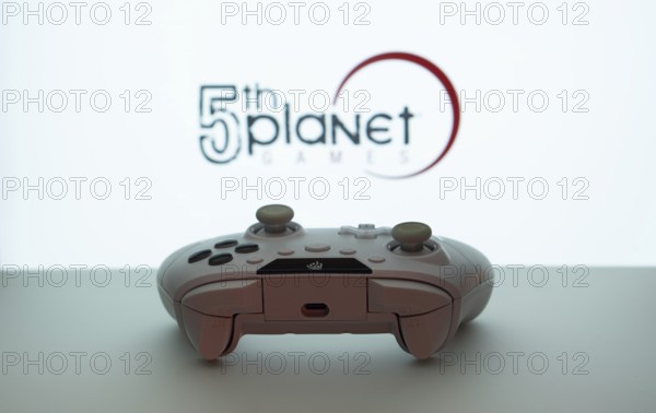 Dhaka, Bangladesh- 23 Sep 2025: Game controller in front of 5th planet games logo on a blue