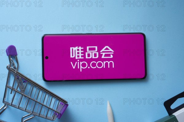 Dhaka, Bangladesh- 03 July 2025: Smartphone displaying vip.com logo with shopping cart on a blue