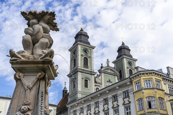 Baroque sculpture next to a building with towers and cloudy sky, Old Cathedral Ignatius Church Old
