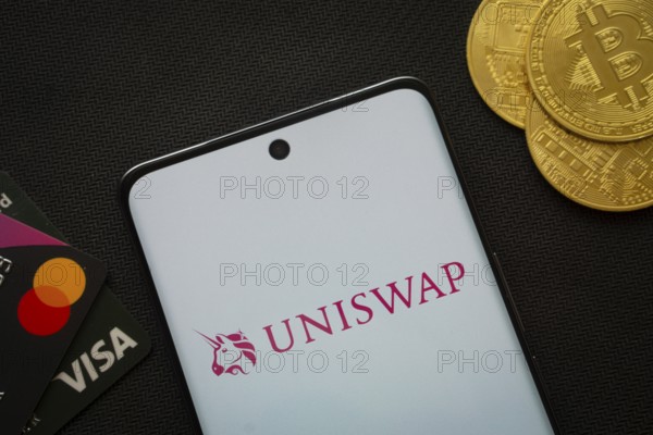 Dhaka, Bangladesh- 19 Sep 2025: Smartphone displaying Uniswap logo surrounded by Bitcoin coins and
