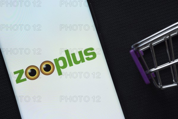 Dhaka, Bangladesh- 03 July 2025: A smartphone displaying the zooplus logo next to a miniature