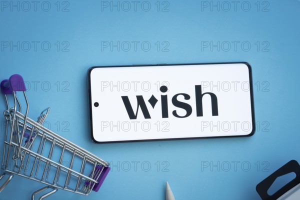 Dhaka, Bangladesh- 03 July 2025: Smartphone displaying Wish logo with shopping cart on a blue