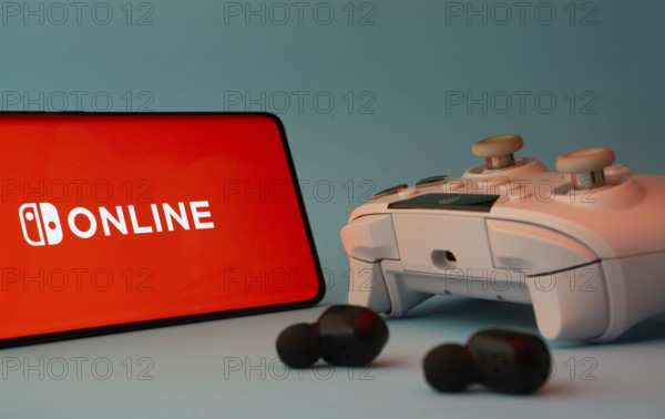 Dhaka, Bangladesh- 15 July 2025: A smartphone with a nintendo online icon next to a controller and