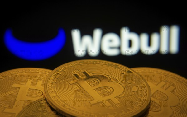 Dhaka, Bangladesh- 27 July 2025: Close-up of Bitcoin coins with the webull logo visible on a screen