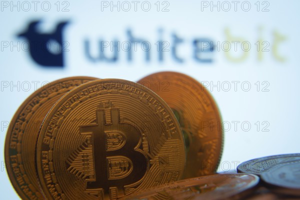 Dhaka, Bangladesh- 03 Sep 2025: Close-up of Bitcoin coins with the whitebit logo visible on a