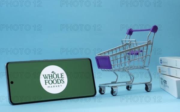 Dhaka, Bangladesh- 03 July 2025: Smartphone with Whole Foods Market logo next to a small shopping