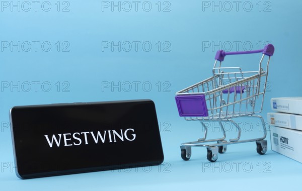 Dhaka, Bangladesh- 03 July 2025: Smartphone with Westwing logo next to a small shopping cart and
