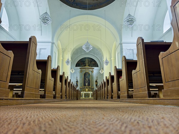 Church interior with view of the altar, wooden benches and quiet atmosphere, Kammersdorf Hollabrunn