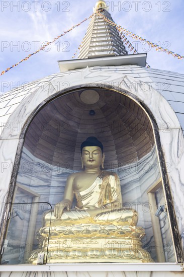 Golden Buddha statue in a stupa, meditating, surrounded by glass protection, Stupa am Wagram