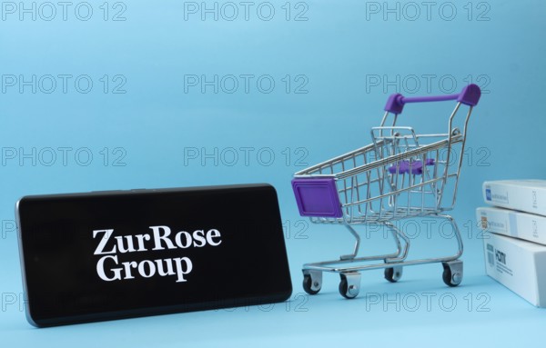 Dhaka, Bangladesh- 03 July 2025: Smartphone with Zur Rose Group logo next to a small shopping cart