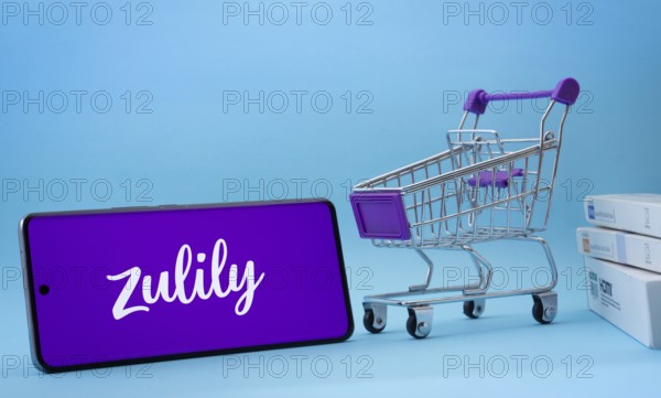 Dhaka, Bangladesh- 03 July 2025: Smartphone with Zulily logo next to a small shopping cart and