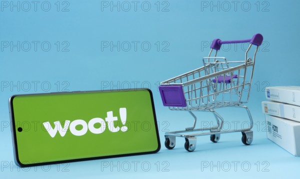 Dhaka, Bangladesh- 03 July 2025: Smartphone with Woot logo next to a small shopping cart and boxes