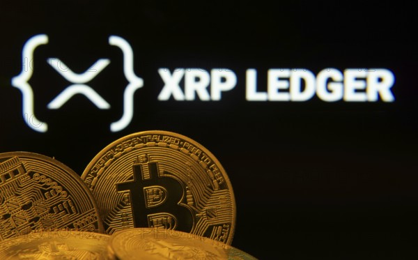 Dhaka, Bangladesh- 27 July 2025: Close-up of Bitcoin coins with the XRP Ledger logo visible on a