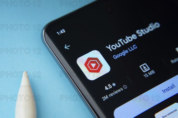 Dhaka, Bangladesh- 29 May 2025: On a blue surface, a smartphone displays the youtube studio app