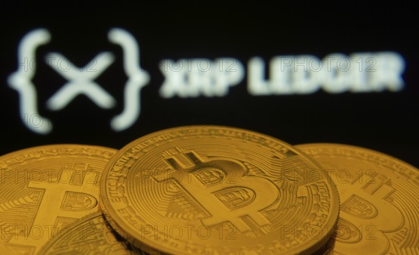 Dhaka, Bangladesh- 27 July 2025: Close-up of Bitcoin coins with the XRP Ledger logo visible on a