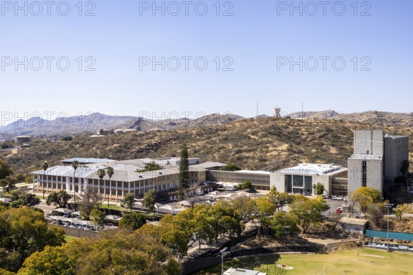 Modern downtown Windhoek, Namibia, with tall contemporary buildings, wide streets, moving cars, and