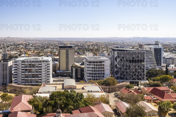 Modern downtown Windhoek, Namibia, with tall contemporary buildings, wide streets, moving cars, and