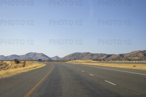 Scenic view of the open road between Windhoek and Outjo, surrounded by dry grasslands and distant