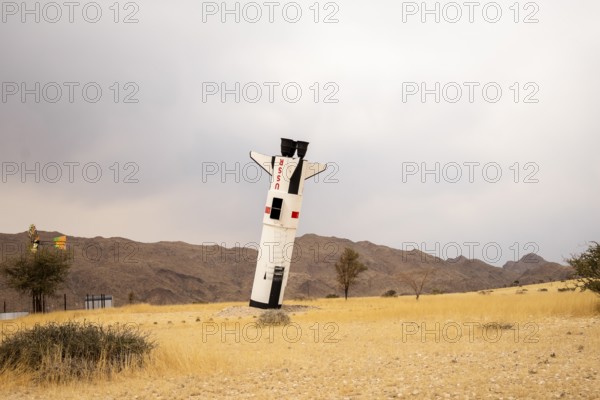 A mock Soviet rocket stands nose-first in the Solitaire, Namibian desert, surrounded by golden