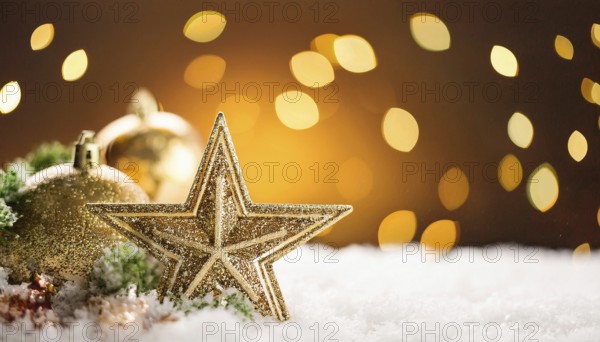 Golden christmas star and baubles creating a magical atmosphere on a snowy surface with warm bokeh