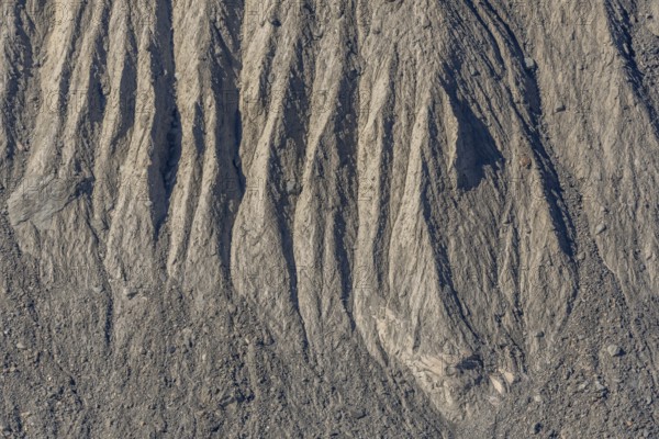 The earth's surface shows clear stripes and reliefs formed by erosion in dry regions. These natural