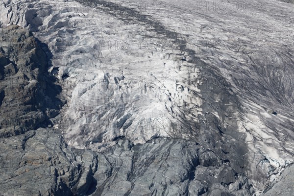 Impressive scene shows lines and textures on residual ice cream in mountains. Daylight emphasises