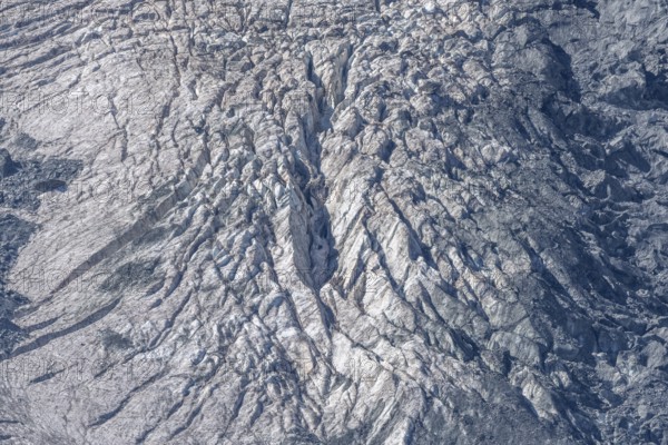 The mountainous landscape reveals impressive glaciers with ice formations and gleaming reflections