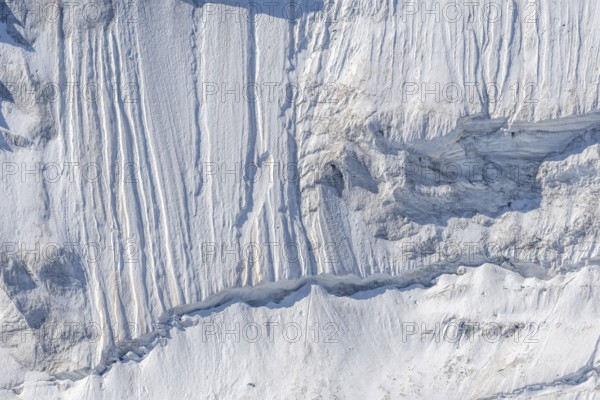 Impressive scene shows lines and textures on residual ice cream in mountains. Daylight emphasises