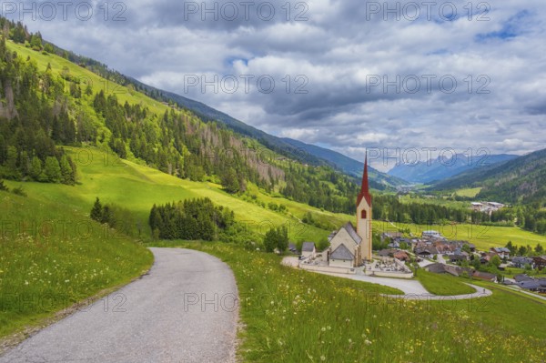View along a road to the church of Winnebach with the valley behind it, San Candido, Val Pusteria,