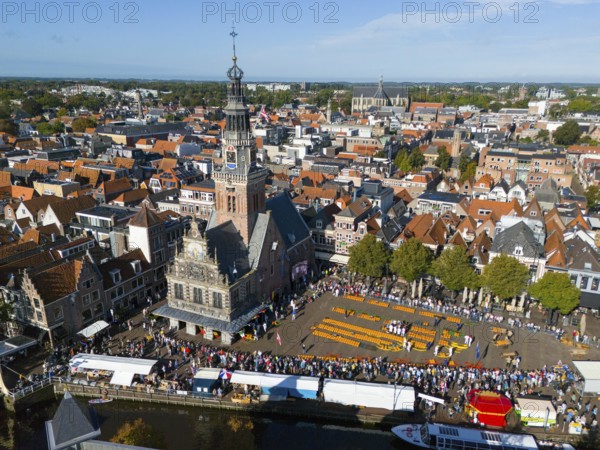 Historic city view with a tower and a busy cheese market in the old town centre, aerial view,
