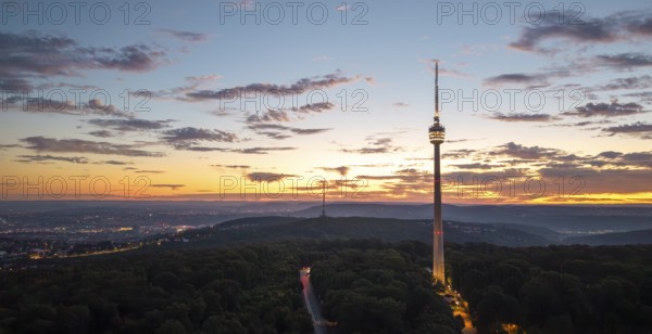 TV tower above wooded area at sunrise with dramatic sky, Stuttgart-Degerloch, Baden-Württemberg,