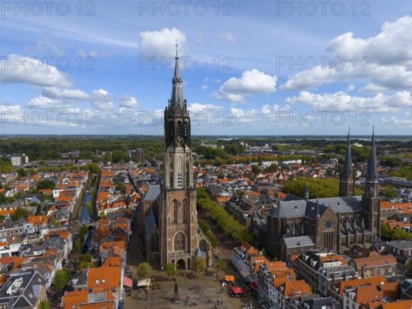 Historic church with high towers in a city with red roofs and clear skies, aerial view, Nieuwe