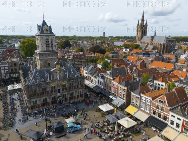 View of the city centre with town hall and lively market square full of people, aerial view, town