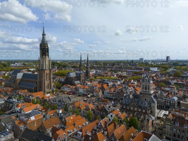 View of the city centre with several churches and red roofs on a cloudy day, aerial view, Nieuwe