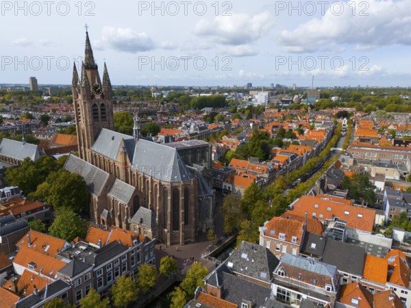 View of the historic city centre with large church and red roofs under a cloudy sky, aerial view,