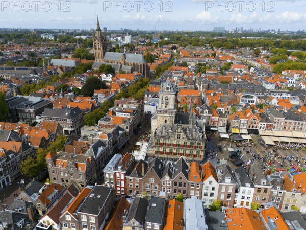 Market square with historic town hall surrounded by red roofs and lively atmosphere, aerial view,