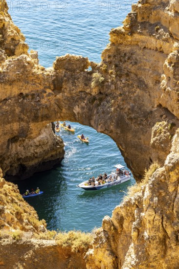 Crowds of excursion boats at the caves and rocky gates of the Ponta da Piedade rocky coast, rugged