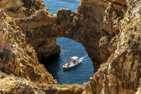 Excursion boats at the caves and rocky gates of the Ponta da Piedade rocky coast, rugged coastal